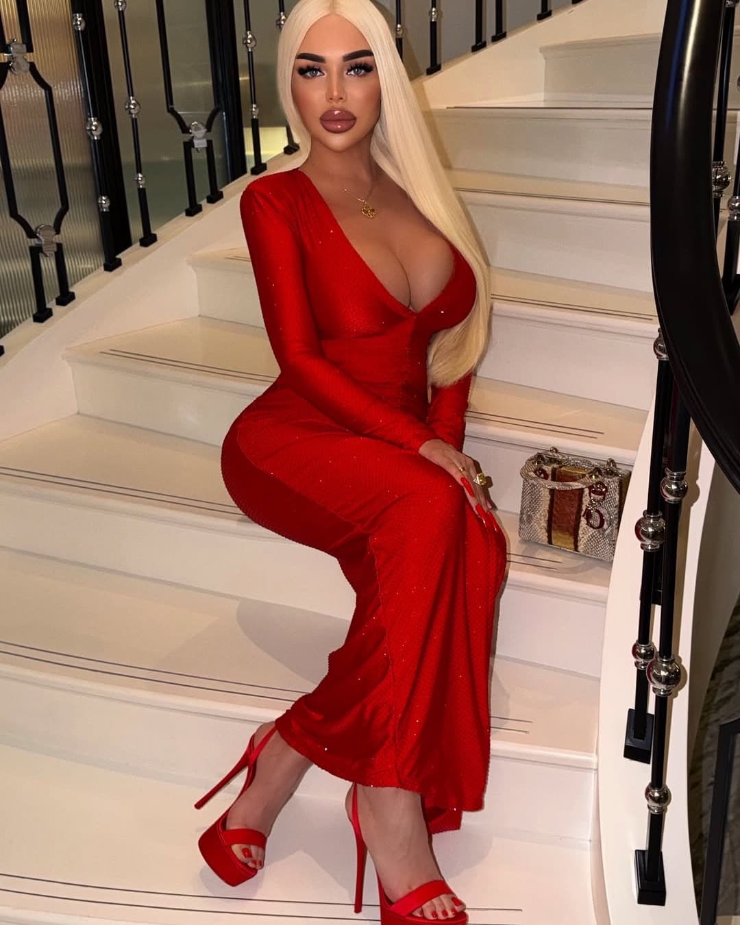 Olga in a red evening dress on a marble staircase